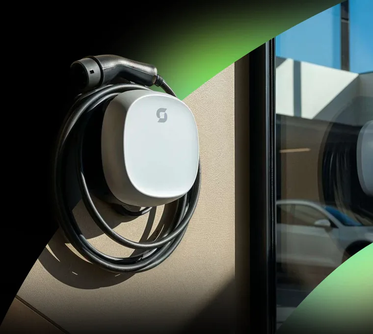 Spin Air wall mounted smart EV charger installed at home with coiled charging cable and Type 2 connector.